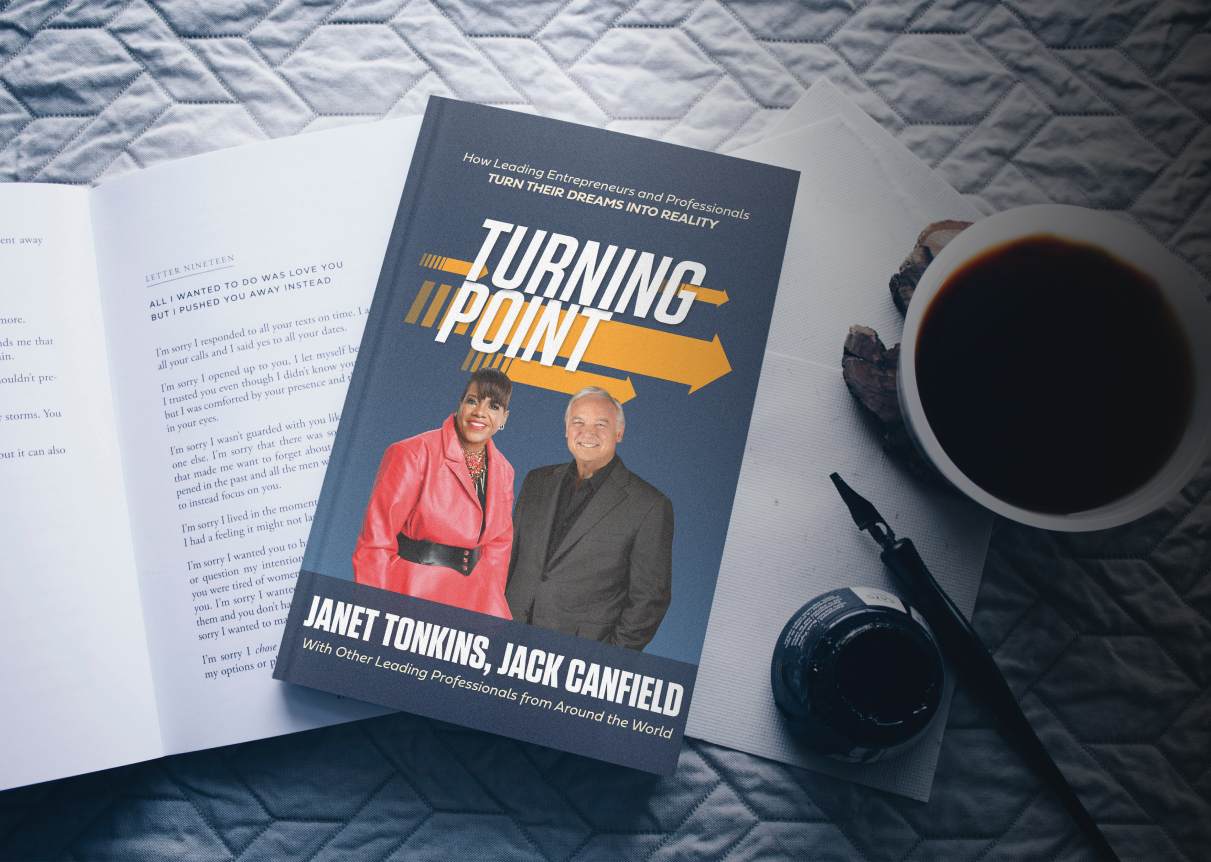 A picture of the book "Turning Point" on top of a table flanked by a pen and a cup of coffee.